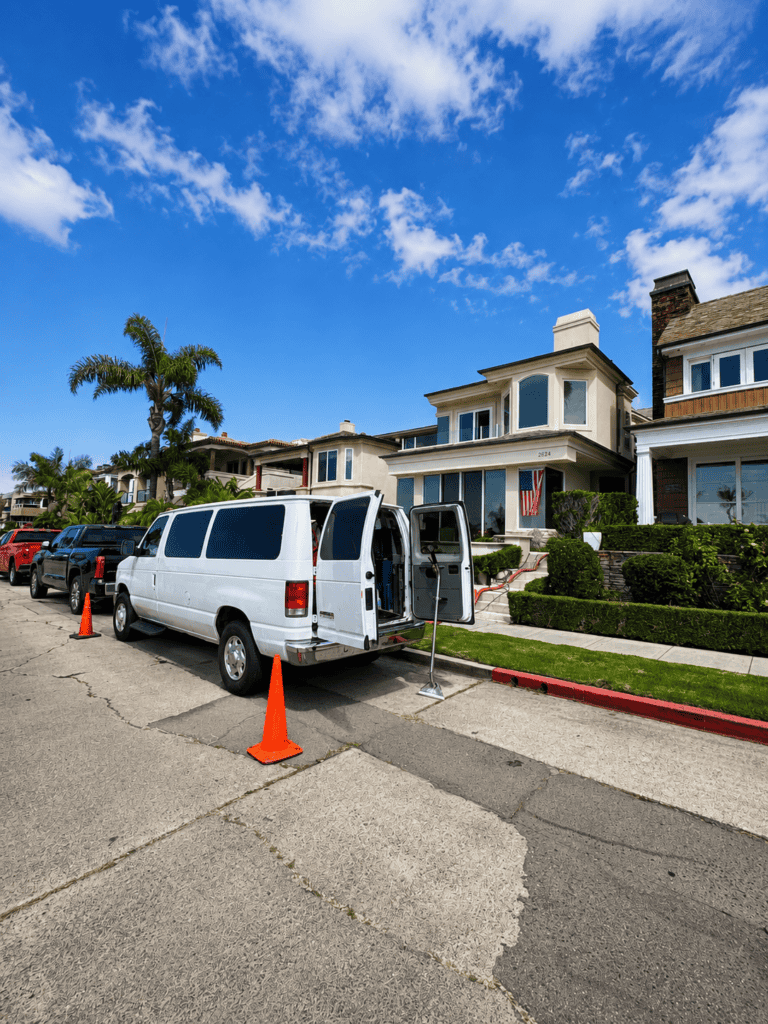 Mobile COVID-19 testing van parked on residential street with orange cones.