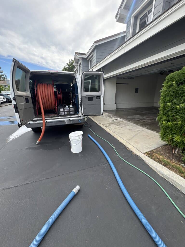 Water extraction and drying equipment outside a residential garage.